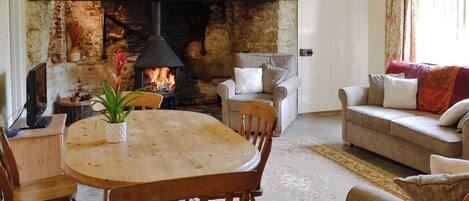 A cozy living room with a fireplace, wooden furniture, and a comfortable sofa.