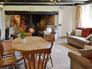 A cozy living room with a fireplace, wooden furniture, and a comfortable sofa.