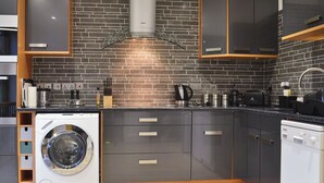 Een moderne keuken met een tegelwand, ingebouwde apparatuur en houten details.