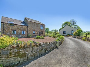 A stone farmhouse with a gravel driveway and a stone wall. - New Park Farm - Church Cottage (near Keswick)