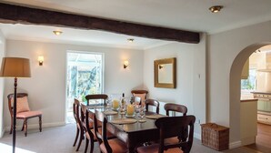 A dining room with a large table, chairs, a lamp, and a window. - A superior detached spacious cottage in an idyllic, truly rural location. (Dockray)