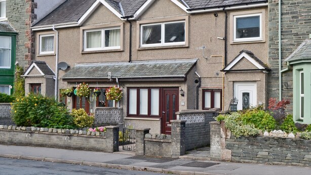 A two-story house with a front garden, a small shop, and a stone wall. - 2 bedroom accommodation in Keswick (Keswick)