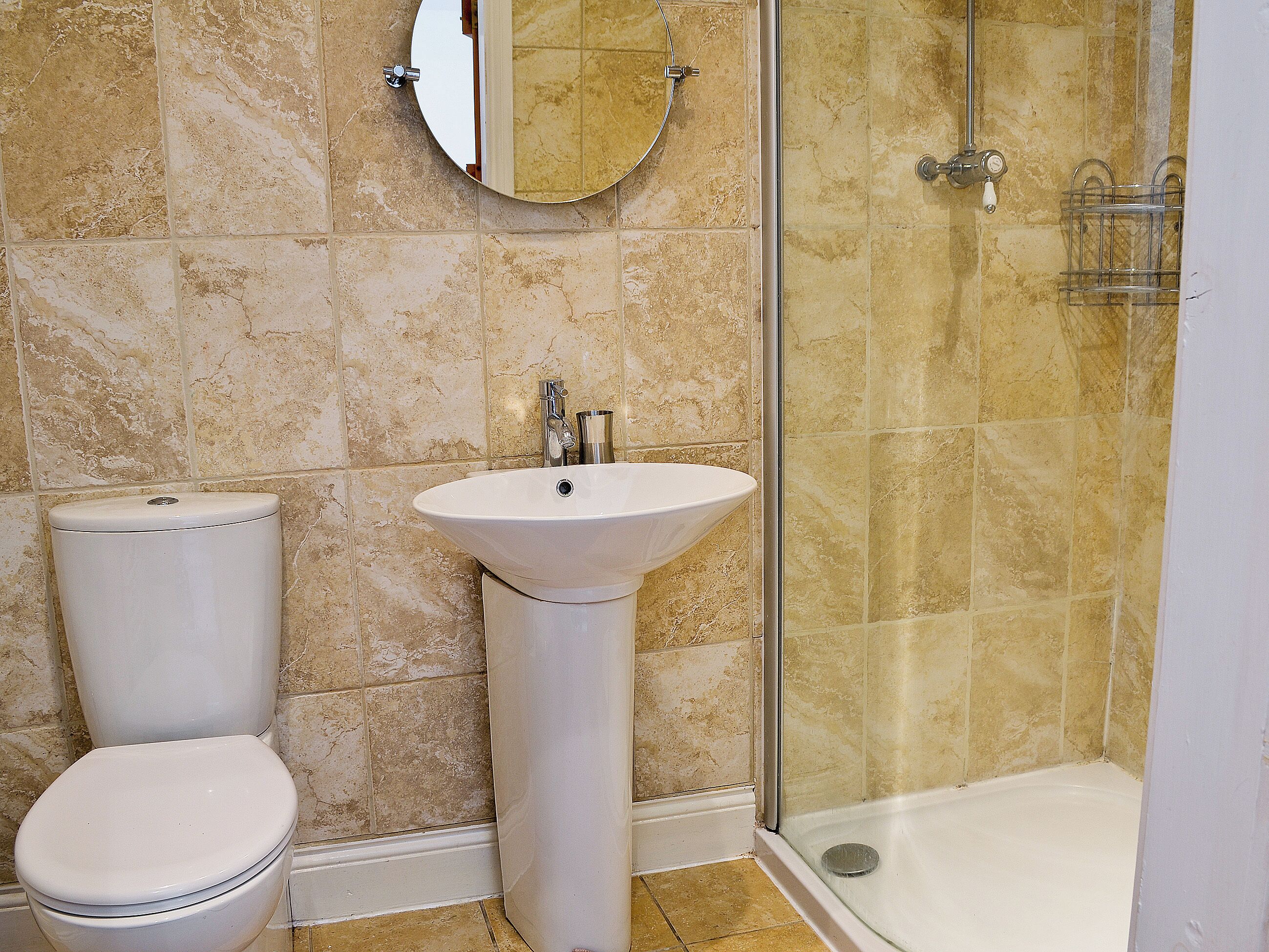 Une salle de bain avec des toilettes, un lavabo et une douche.