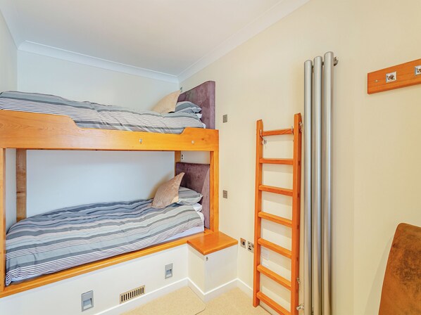 A bunk bed with a wooden ladder and a radiator on the wall. - 3 steps to entrance. (Ripon)