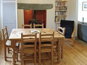 A dining area with a wooden table and chairs, a bookshelf, and a fireplace. - 2 bedroom accommodation in Ambleside (Ambleside)