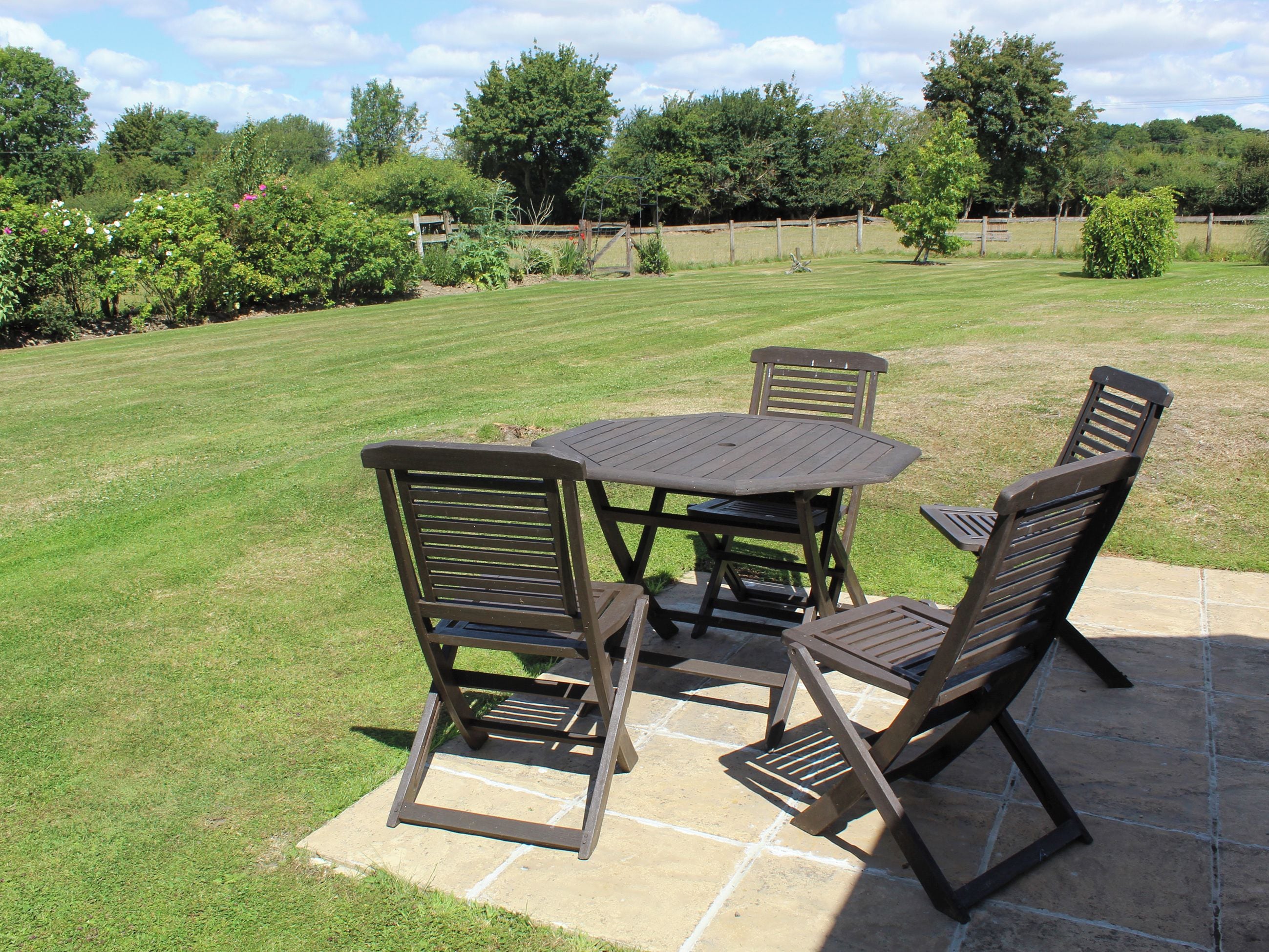 An outdoor patio with a table and four chairs.