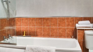 Een badkamer met een bad, een douche en een toilet.