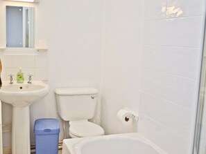 Une salle de bain avec un lavabo, des toilettes et une baignoire.