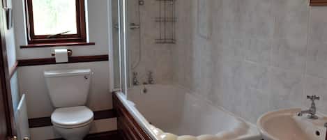 Un baño con inodoro, bañera y lavabo.