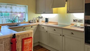 A kitchen with a sink, cabinets, and a fire blanket. - 2 bedroom accommodation in Filey (Filey)