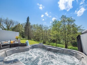 A hot tub surrounded by a lush garden with a clear sky. - 2 bedroom accommodation in Llandeilo (Llandeilo)
