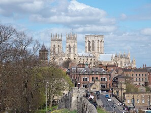 A historic cathedral with intricate architecture, a stone bridge, and a street with pedestrians.