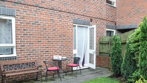 A brick building with a patio area featuring a bench, two chairs, and a small table. - 3 bedroom accommodation in York (York)