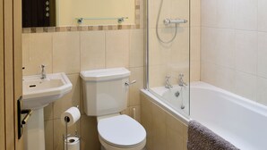 Een badkamer met toilet, wastafel en bad.