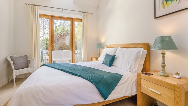 A bedroom with a bed, bedside tables, a chair, a window, and a painting on the wall. - 2 bedroom accommodation in Tealing, near Dundee (Tealing, near Dundee)