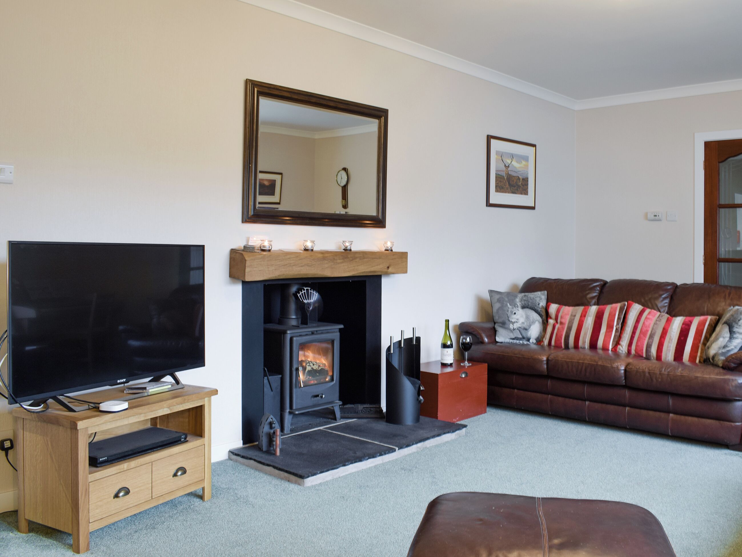 A living room with a fireplace, a television, a sofa, and a coffee table.