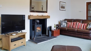 A living room with a fireplace, a television, a sofa, and a coffee table.