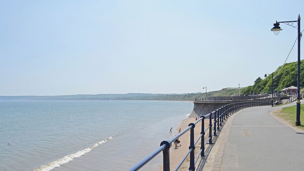 A seaside promenade with a paved walkway, a stone wall, and a clear sky. - 2 bedroom accommodation in Filey (Filey)