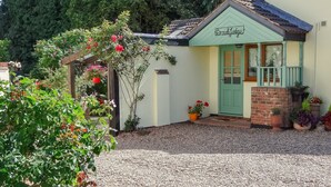 Een charmant landhuis met een groene deur en een bordje met de tekst 'Brook Lodge'.