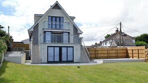 A two-story house with a balcony, a front door, and a staircase leading to the entrance. - 1 bedroom accommodation in Port Isaac (Port Isaac)