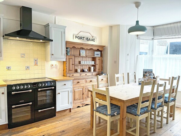 A kitchen with a stove, cabinets, and a sign that reads 'PORT ISAAC'.