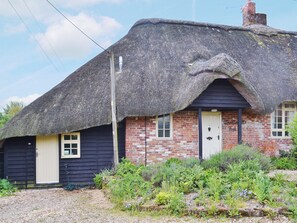A traditional thatched-roof cottage with a brick extension, a white door, and a small window. - 1 bedroom accommodation in Burgate, near Fordingbridge (Burgate, near Fordingbridge)
