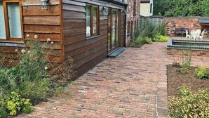 A wooden cabin with a brick pathway leading to the entrance. - 3 bedroom accommodation in Kidderminster (Kidderminster)