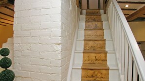 A staircase with white painted steps and a white brick wall. - An unusual two-storey apartment with beams and an open fire. (Rye)