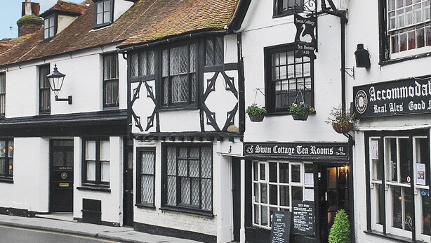 A traditional building with a sign for 'Swan Cottage Tea Rooms' and 'Accommodations' offering real ales and good food. - An unusual two-storey apartment with beams and an open fire. (Rye)