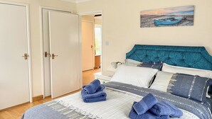 A bedroom with a bed, a headboard, a painting, and a door. - 1 bedroom accommodation in East Taphouse, near Liskeard (East Taphouse, near Liskeard)