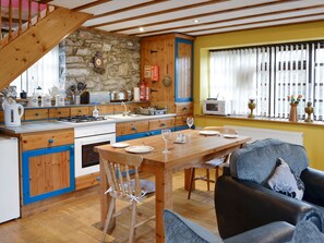 A kitchen with a wooden table, chairs, and a dining area.