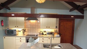 Una cucina con isola centrale, microonde, tostapane e lavello.