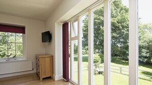 A room with large windows, a radiator, and a wooden cabinet. - 2 bedroom accommodation in Sutton Bridge, Spalding (Sutton Bridge, Spalding)