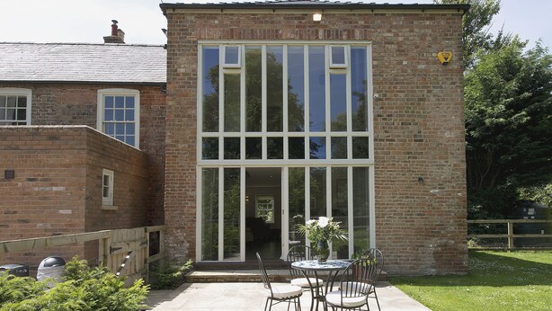 A brick building with large windows and a patio with outdoor furniture. - 2 bedroom accommodation in Sutton Bridge, Spalding (Sutton Bridge, Spalding)