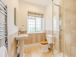 Un baño con inodoro, lavabo y ducha.