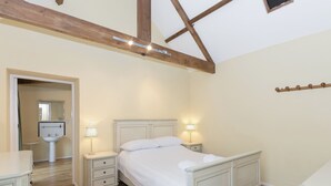 Ein Schlafzimmer mit Bett, Nachttischen, einem Spiegel und einem Waschbecken.