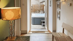 A hallway with a wooden bench, a lamp, and a bench with a patterned cover. - Kielder Cottage Spa - E3533 (Kielder)