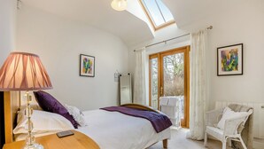A bedroom with a bed, bedside lamp, and a chair. - 1 bedroom accommodation in Tealing, near Dundee (Tealing, near Dundee)