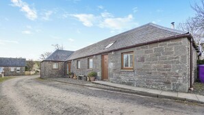 A stone building with a gravel driveway and a wooden door. - 1 bedroom accommodation in Tealing, near Dundee (Tealing, near Dundee)