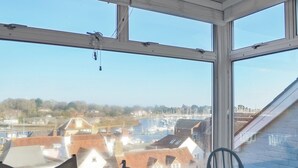 Ein Zimmer mit großem Fenster und Blick auf einen Yachthafen und Gebäude.