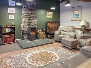 A cozy living room with a stone fireplace, leather furniture, and a patterned rug. - 3 bedroom accommodation in Blawith, near Coniston (Blawith, near Coniston)