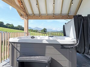 A hot tub with a wooden pergola overhead, a view of a grassy field, and mountains in the distance. - 3 bedroom accommodation in Blawith, near Coniston (Blawith, near Coniston)