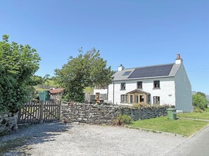 A white house with a stone wall, a wooden gate, and a gravel driveway. - 3 bedroom accommodation in Blawith, near Coniston (Blawith, near Coniston)