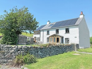 A two-story house with a stone wall, a wooden door, and a small porch. - 3 bedroom accommodation in Blawith, near Coniston (Blawith, near Coniston)