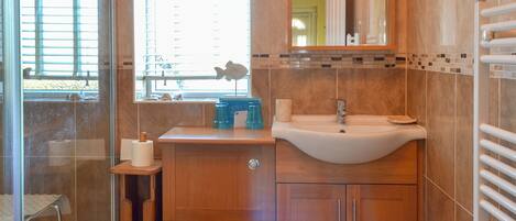 A bathroom with a toilet, sink, and shower area.