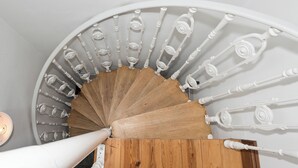 Una escalera de caracol con barandillas blancas y escalones de madera.