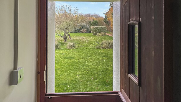 A door with a view of a grassy yard and trees. - 2 bedroom accommodation in Shaftesbury (Shaftesbury)