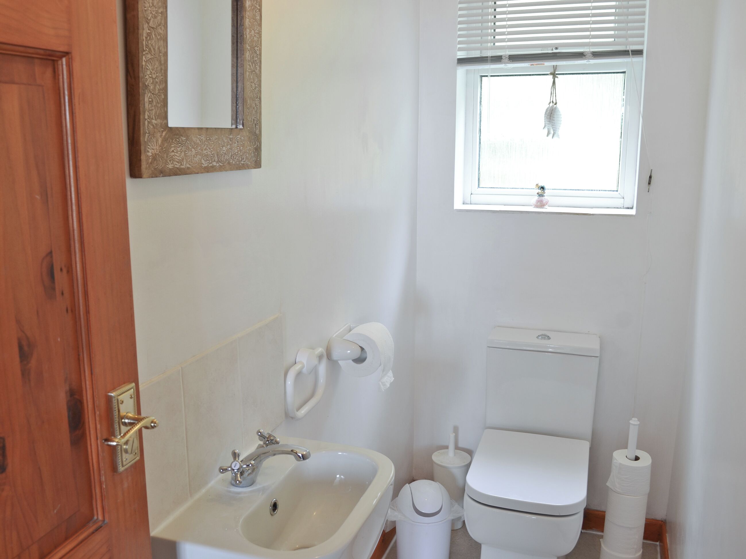 Ein Badezimmer mit Waschbecken, Toilette und Fenster.