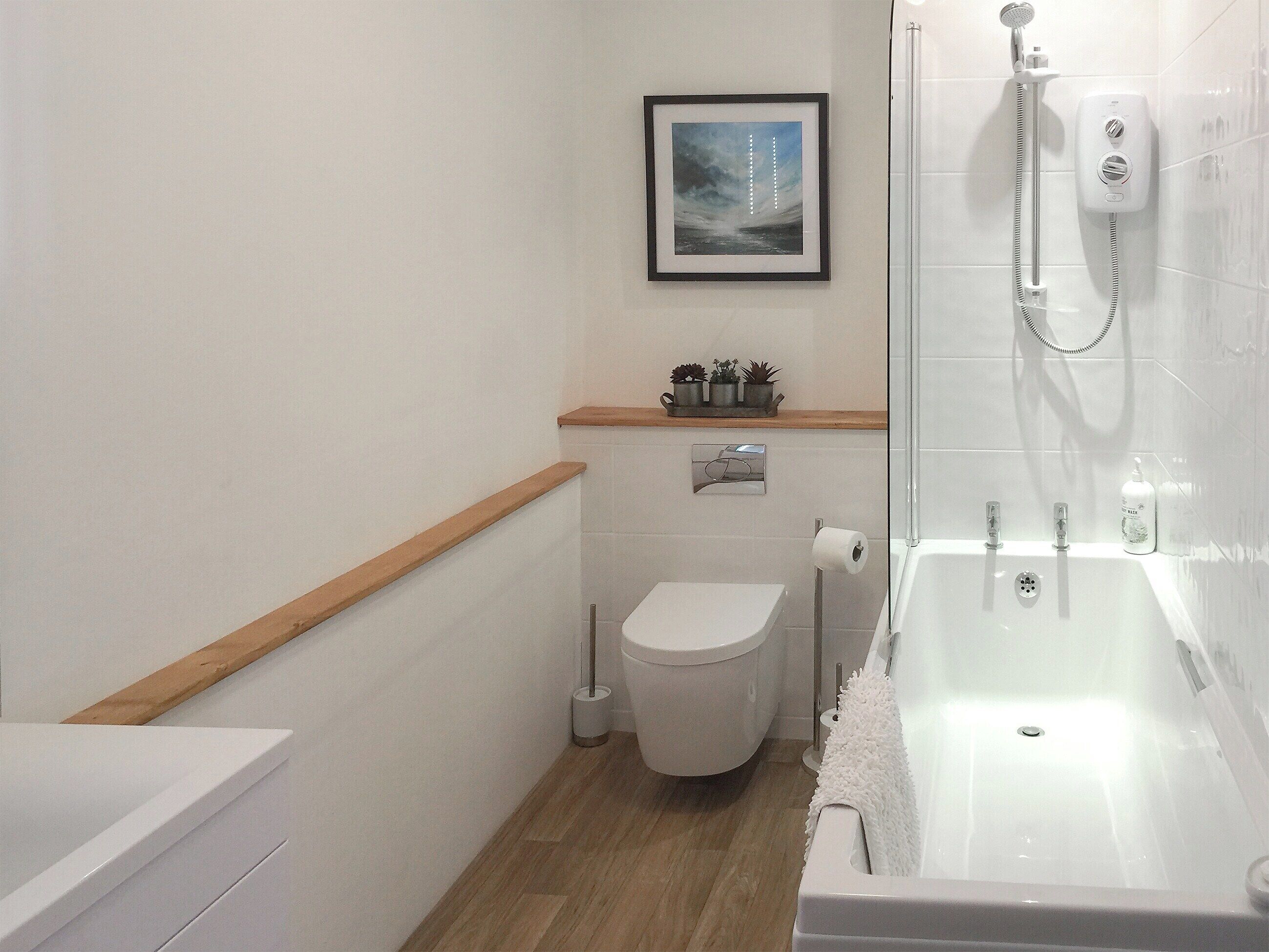 Un baño moderno con inodoro, lavamanos y bañera.