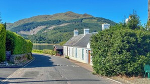 A road leading to a building with a mountain in the background. - 2 bedroom accommodation in Ardentinny near Dunoon (Ardentinny near Dunoon)